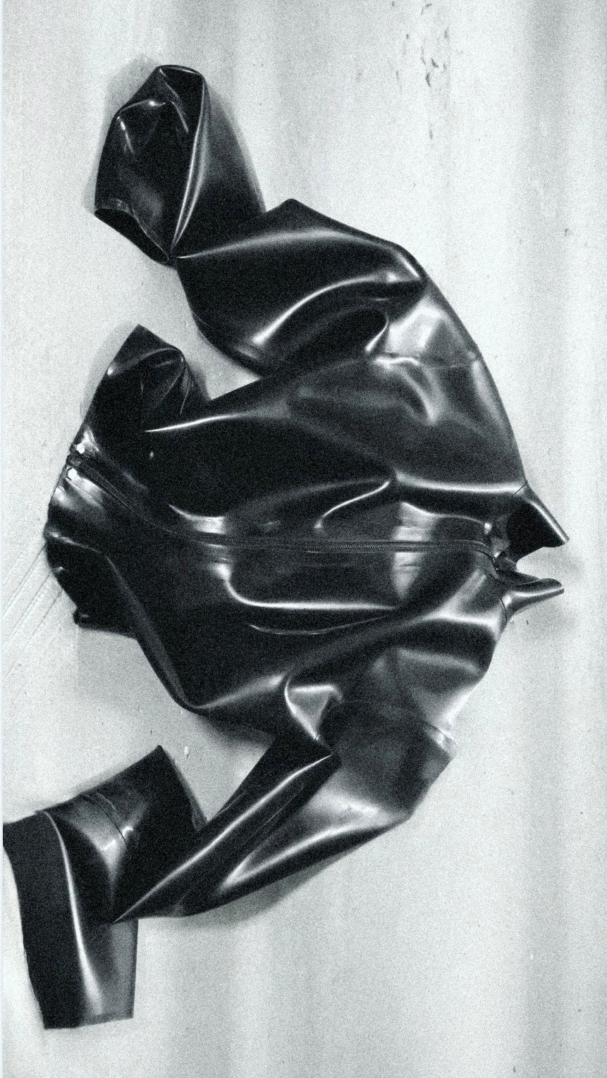 Black, crumpled latex jacket on a concrete background